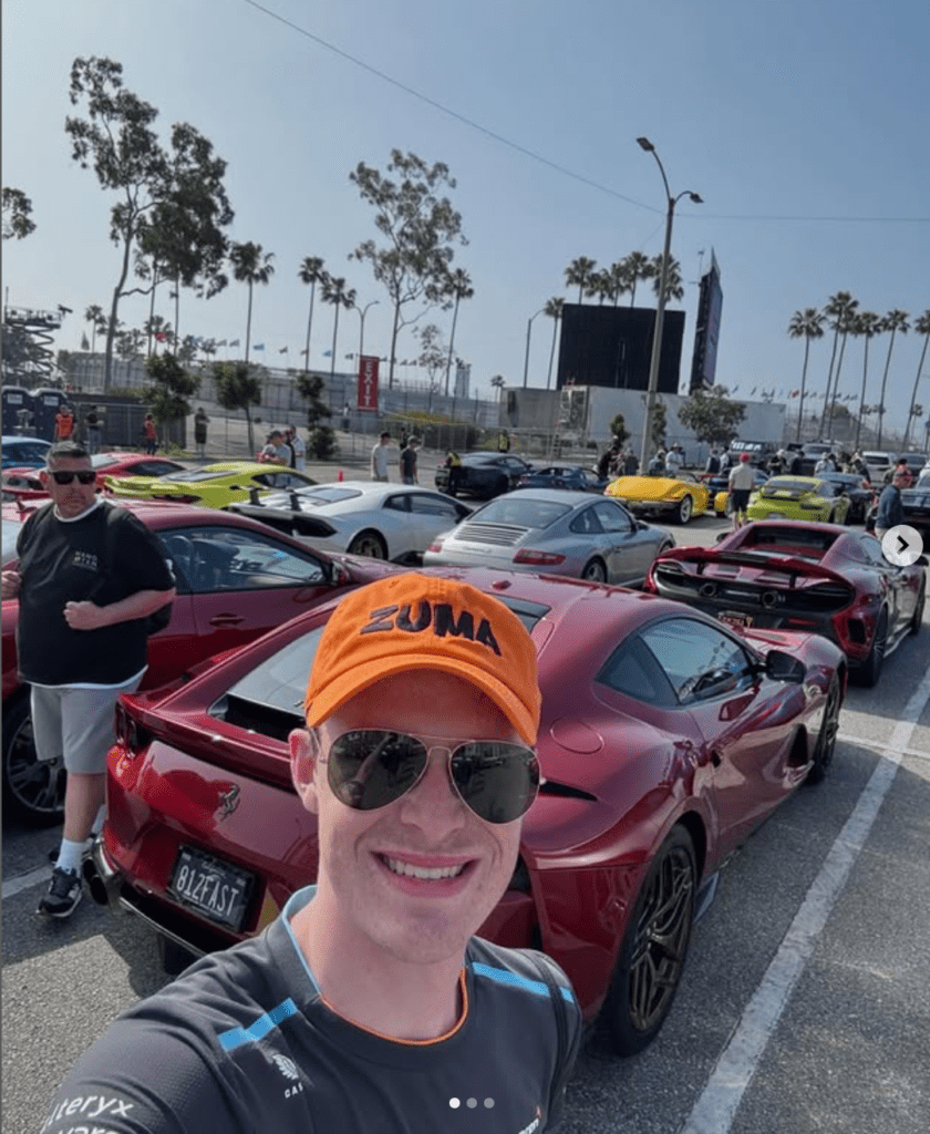A group of sports cars parked outdoors with people around.